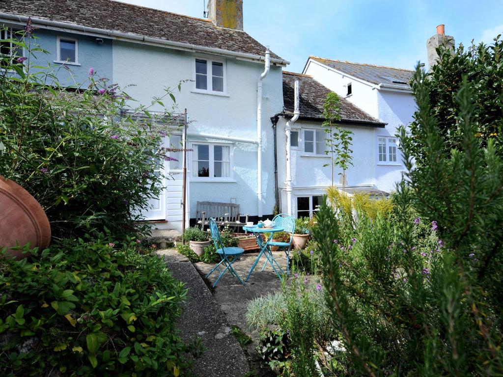 una casa blanca con una mesa y sillas en un patio en 30 Sherborne Lane, en Lyme Regis