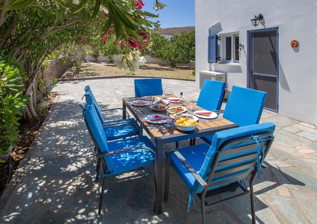 a table and chairs with a meal on a patio at Ruby's summer house with spacious garden and free parking in Gavrion