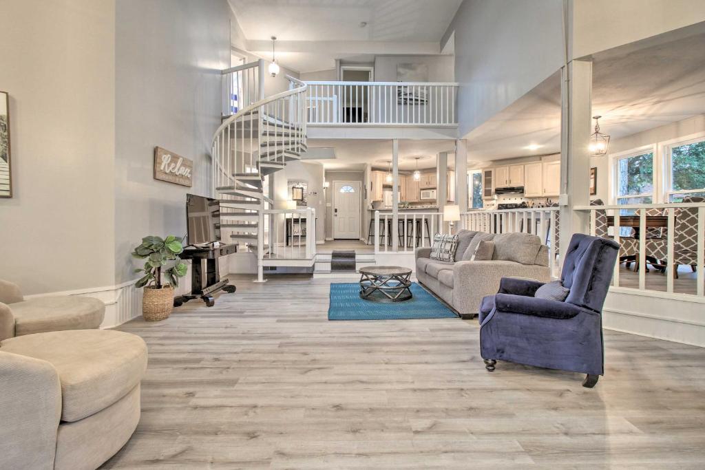 a living room with couches and a spiral staircase at Riverfront Savannah Getaway with Pool and Dock! in Savannah