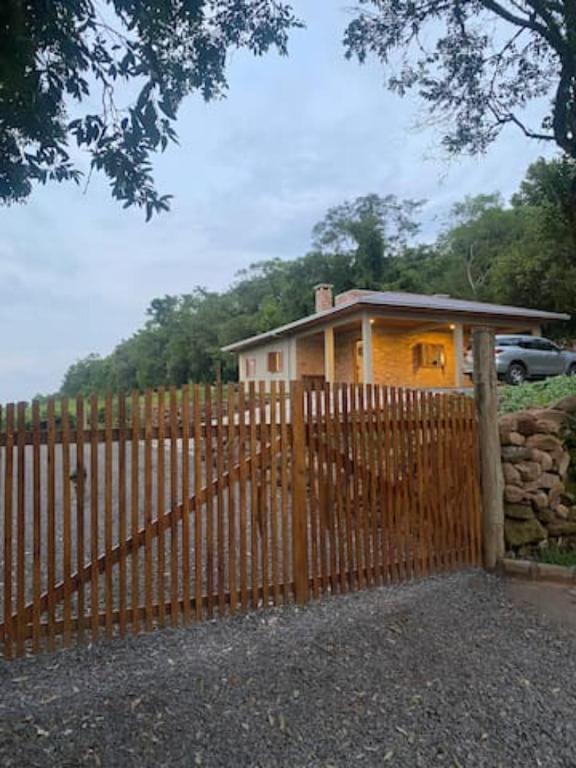 une clôture en bois devant une maison dans l'établissement Casa, sítio, aconchegante no Vale dos Vinhedos., à Bento Gonçalves