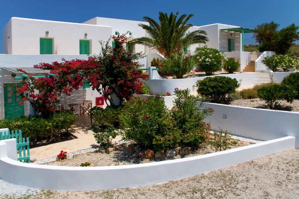 a garden in front of a white building with flowers at Psilandis Studios in Adamantas