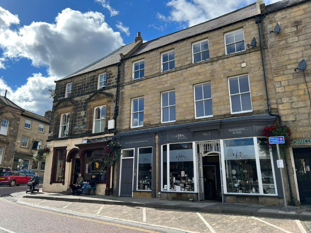 a building on a city street with a store at Angel Lane Alnwick Apartment in Alnwick