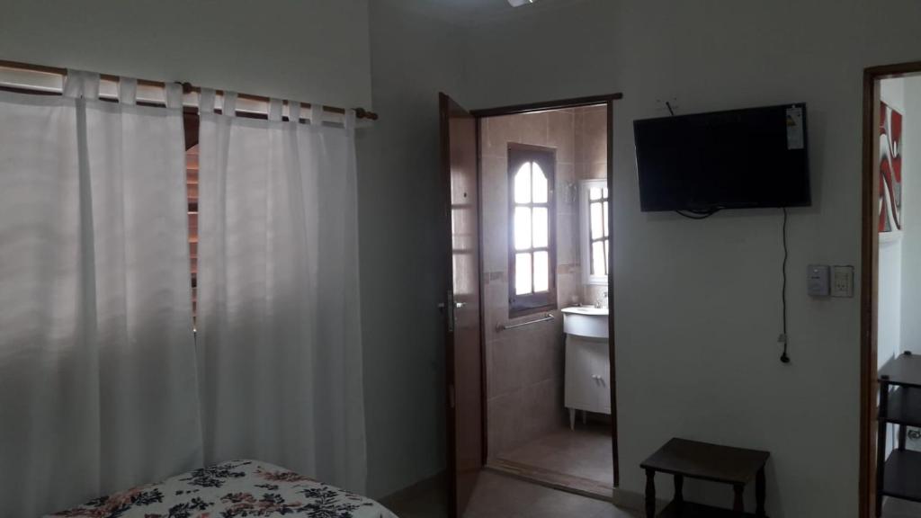 1 dormitorio con cama, ventana y TV en Alojamiento Guemes en Gualeguay