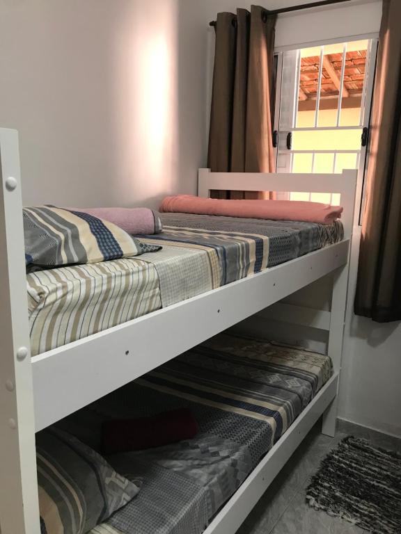 a white bunk bed in a room with a window at Pousada da Benção in Cachoeira Paulista