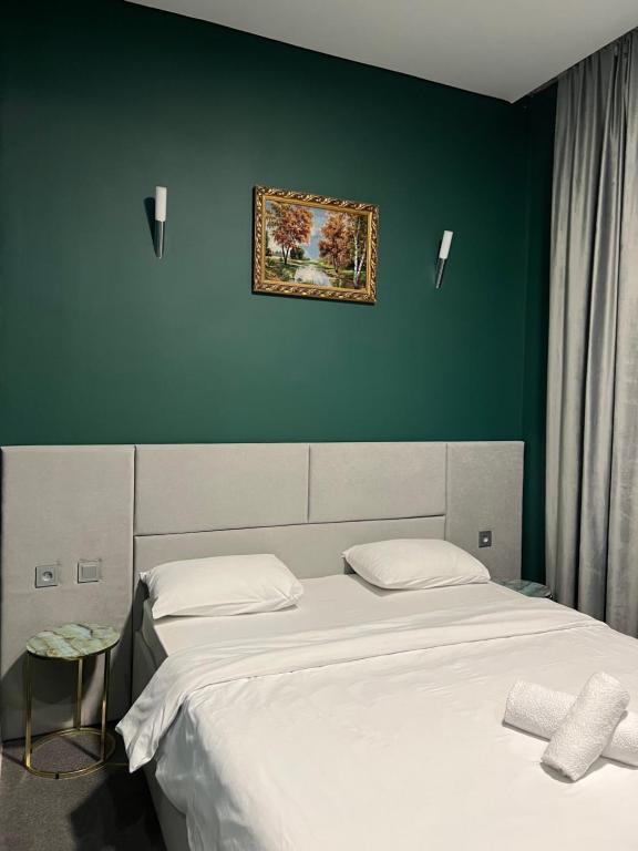 - une chambre avec 2 lits et un tableau mural dans l'établissement Hotel NOMAD, à Aqtöbe