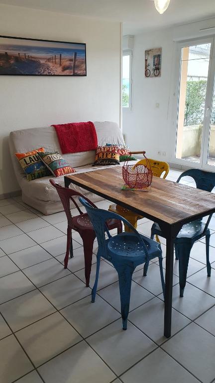 - un salon avec une table et des chaises en bois dans l'établissement l'hippocampe, à Cayeux-sur-Mer