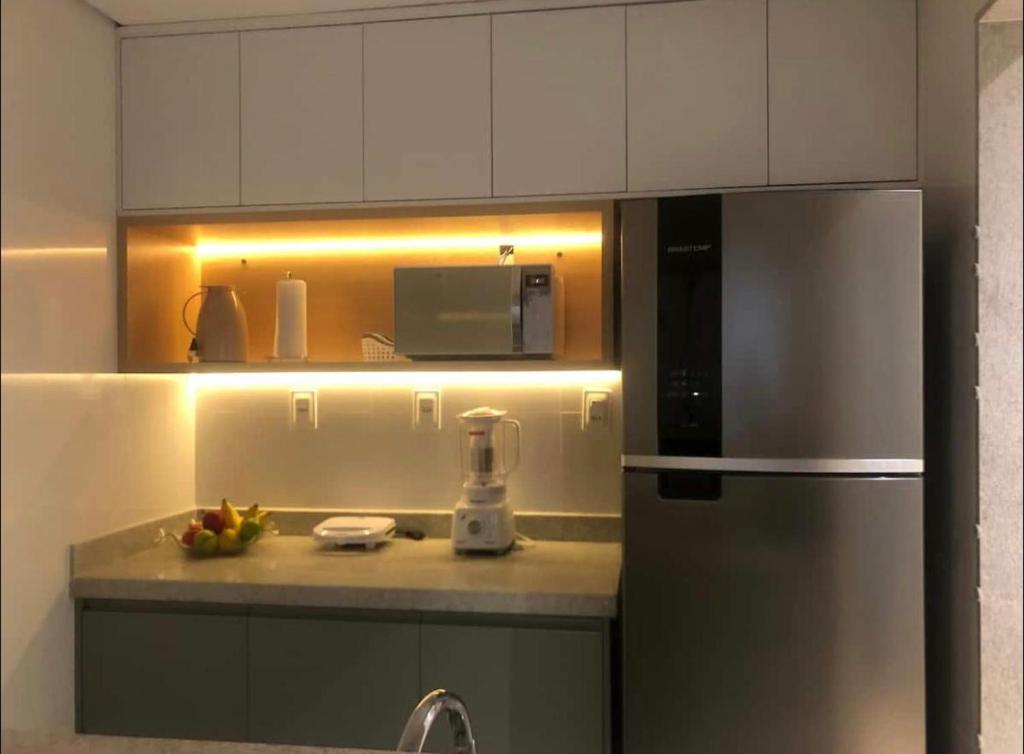 a kitchen with a stainless steel refrigerator and a microwave at Diamond é o seu lugar ! in Belo Horizonte