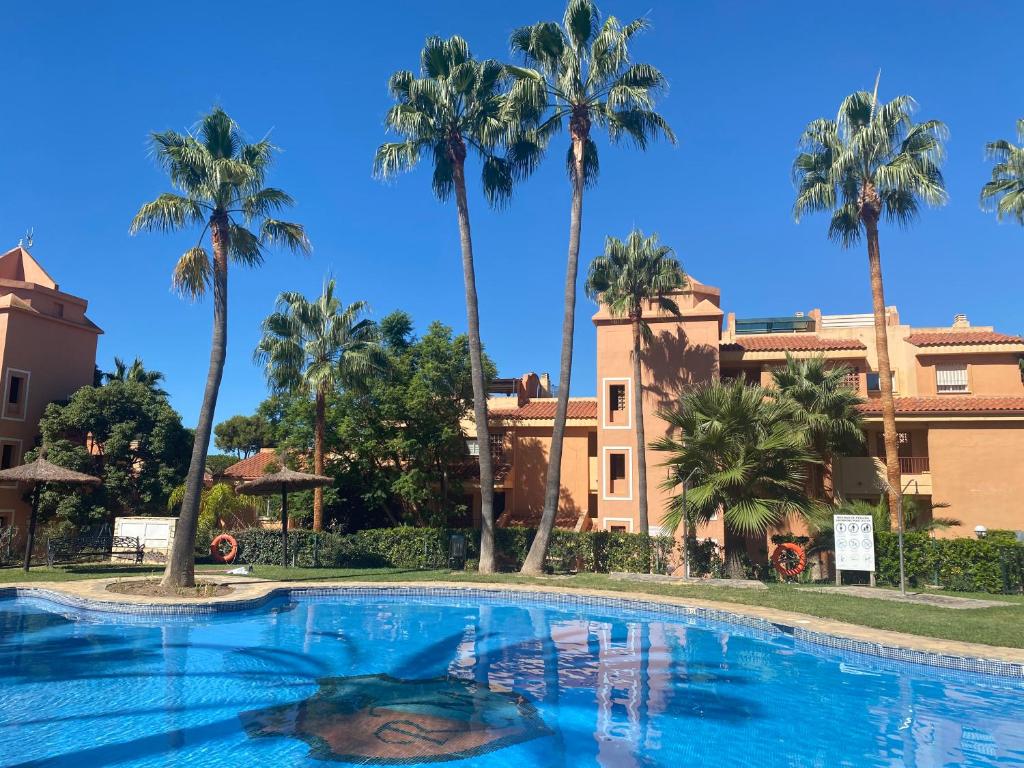 ein Pool mit Palmen im Hintergrund in der Unterkunft Apartamento con gran terraza and view in Marbella