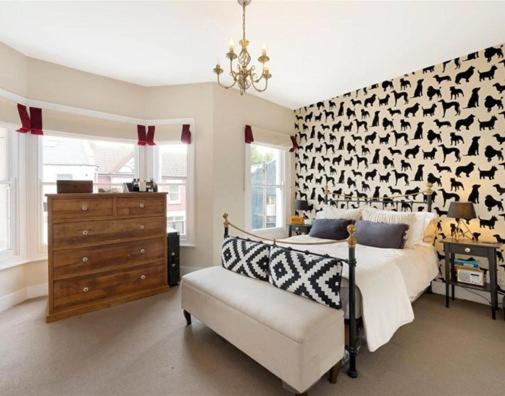 a bedroom with a bed and a chair and a dresser at Battersea boutique townhouse in London