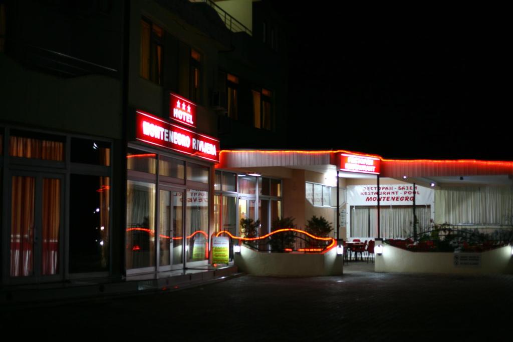 a building with neon signs in front of it at night at Hotel&SpaMontenegro Rivijera in Veles