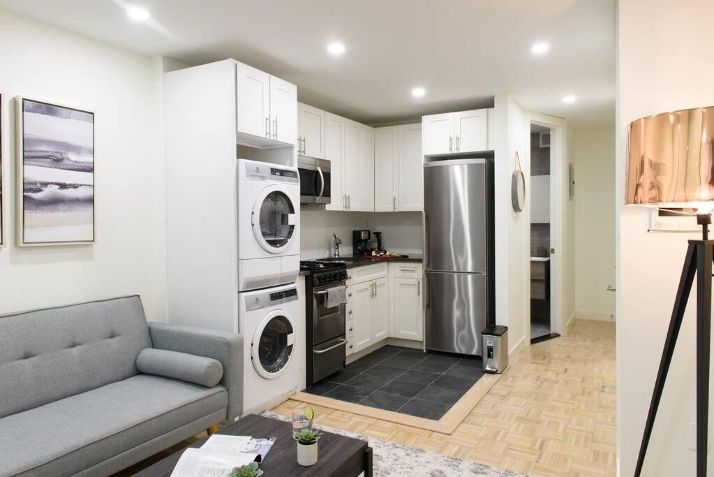 eine Küche mit Sofa und Geräten in einem Zimmer in der Unterkunft 75-2B Prime Upper East Brand New 1BR W D Elev in New York