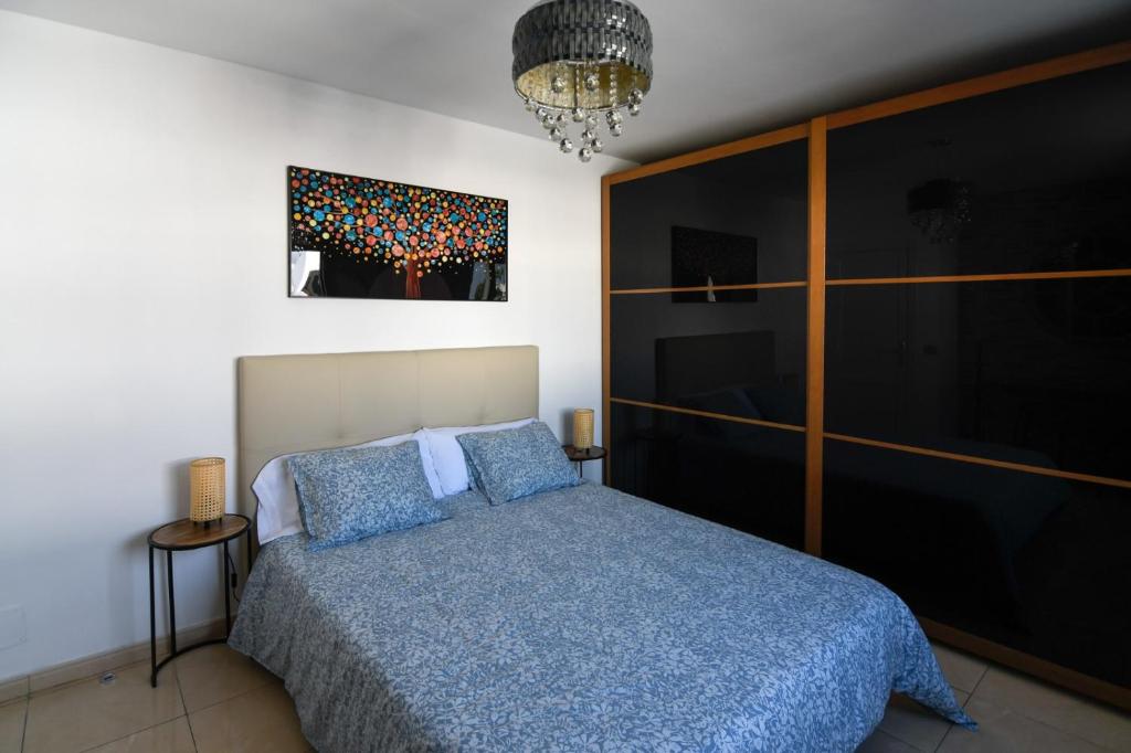 1 dormitorio con 1 cama y una pintura en la pared en CASA CUADERNA a 150 metros de la playa en Playa Honda