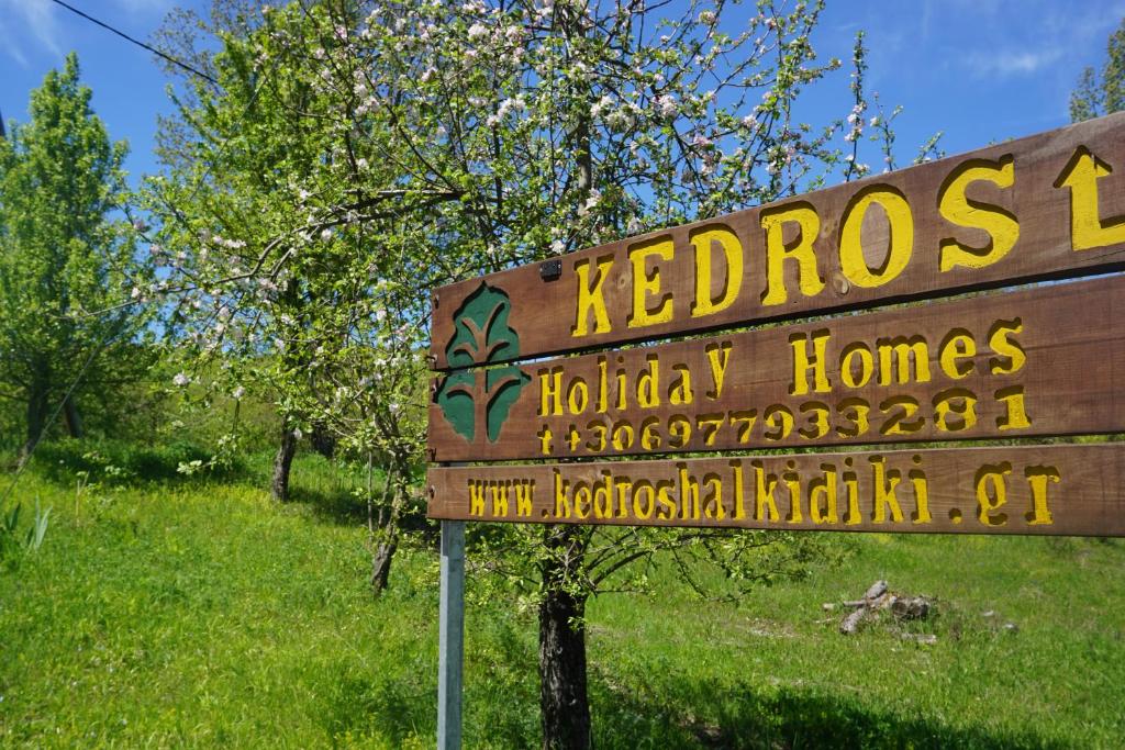 ein Holzschild auf einem Feld neben einem Baum in der Unterkunft Kedros in Neokhórion