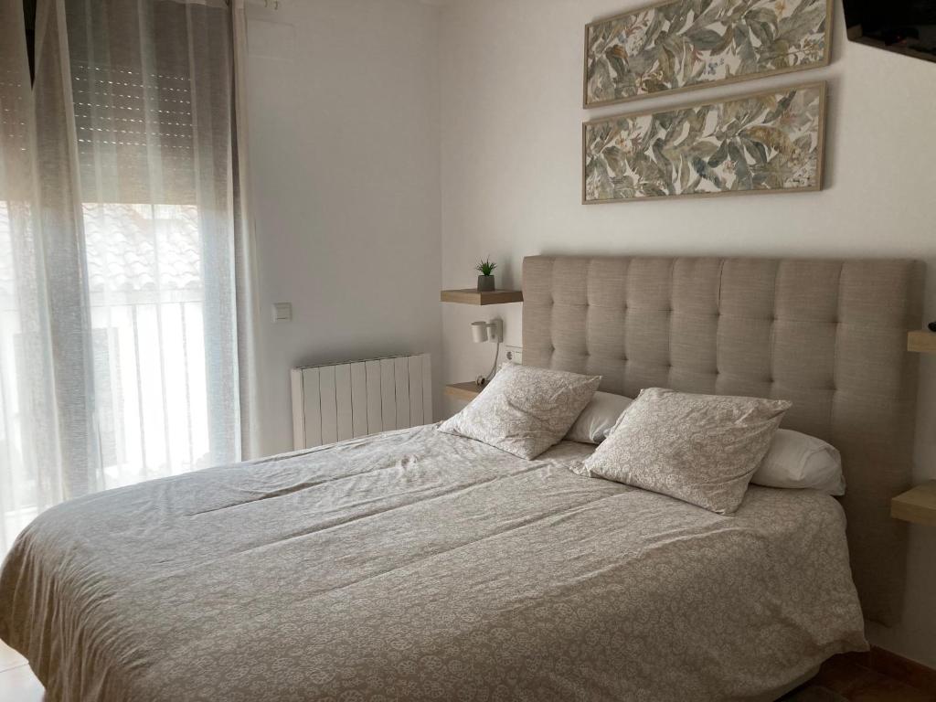 um quarto com uma grande cama branca e 2 almofadas em Casa ELENA i MARTA , Valdelinares em Valdelinares