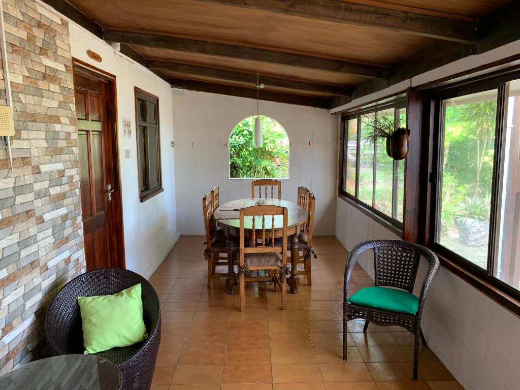 una sala da pranzo con tavolo e sedie di Amitie Chalets Praslin a Grand Anse