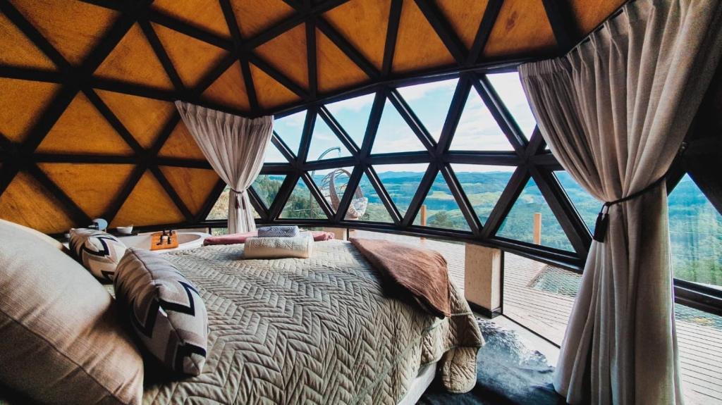1 dormitorio con 1 cama en una habitación con ventana grande en THE SPACE - Welcome to the sky - Domo Geodésico en Barracão
