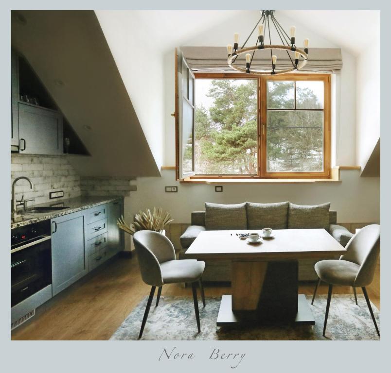 a kitchen and dining room with a table and chairs at Nora Berry in Nida