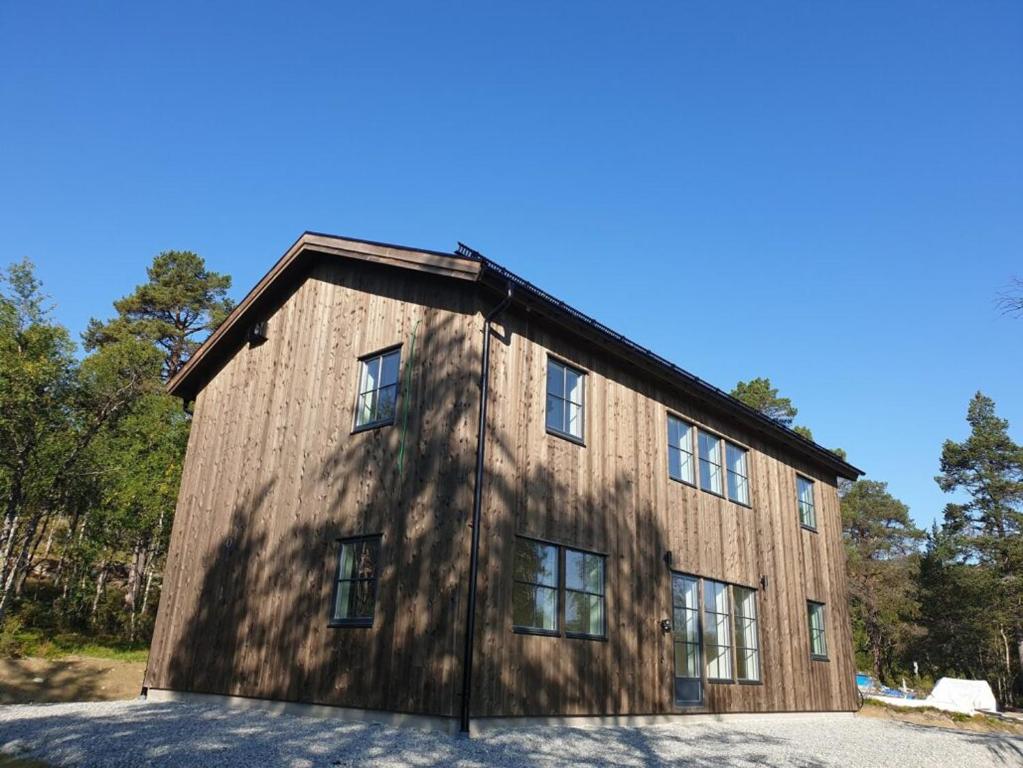 un gran edificio de madera con ventanas laterales. en Bruksvallarna Lullens stugby en Bruksvallarna