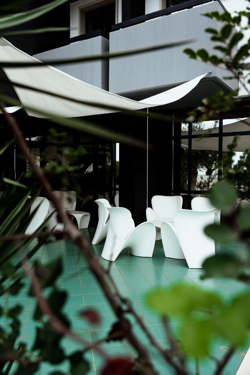 a group of white chairs and an umbrella at Tuo Hotel in Polignano a Mare