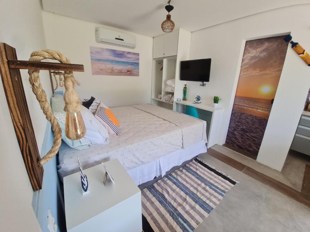 a small bedroom with a bed and a television at Summervilleflatsbg o seu apt studio em BG in Barra Grande