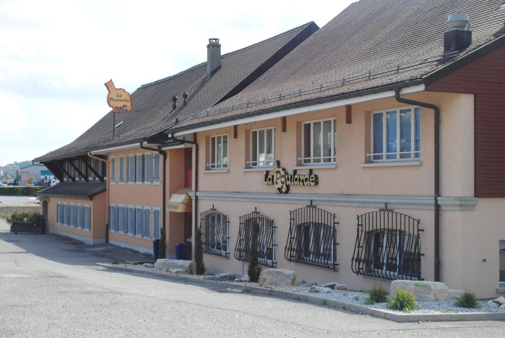 a building with bars on the windows on a street at Motel - Hôtel La Poularde in Romont