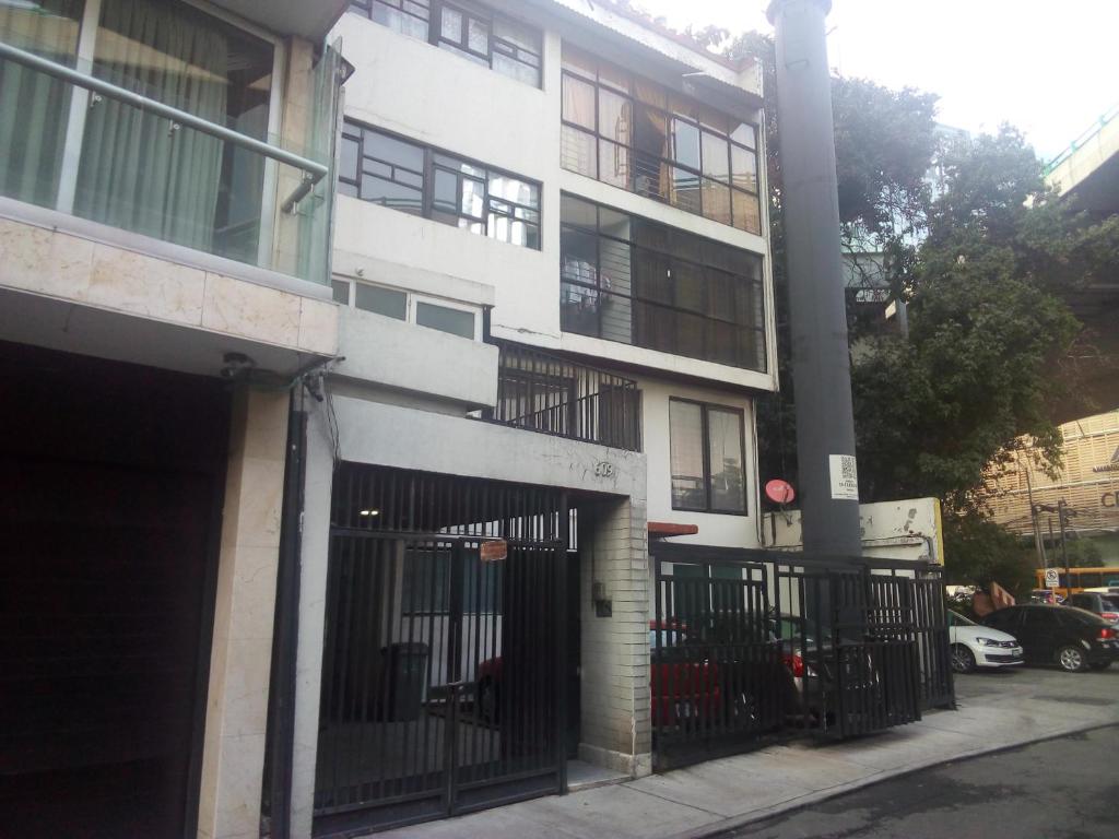 un bâtiment blanc avec une porte devant dans l'établissement Alcoba en Polanco (solo hombres), à Mexico