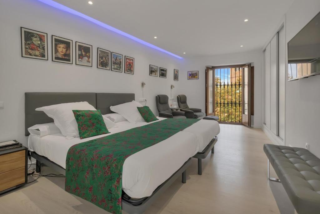 a hotel room with a large bed and chairs at Hotel Ronda Nuevo in Ronda