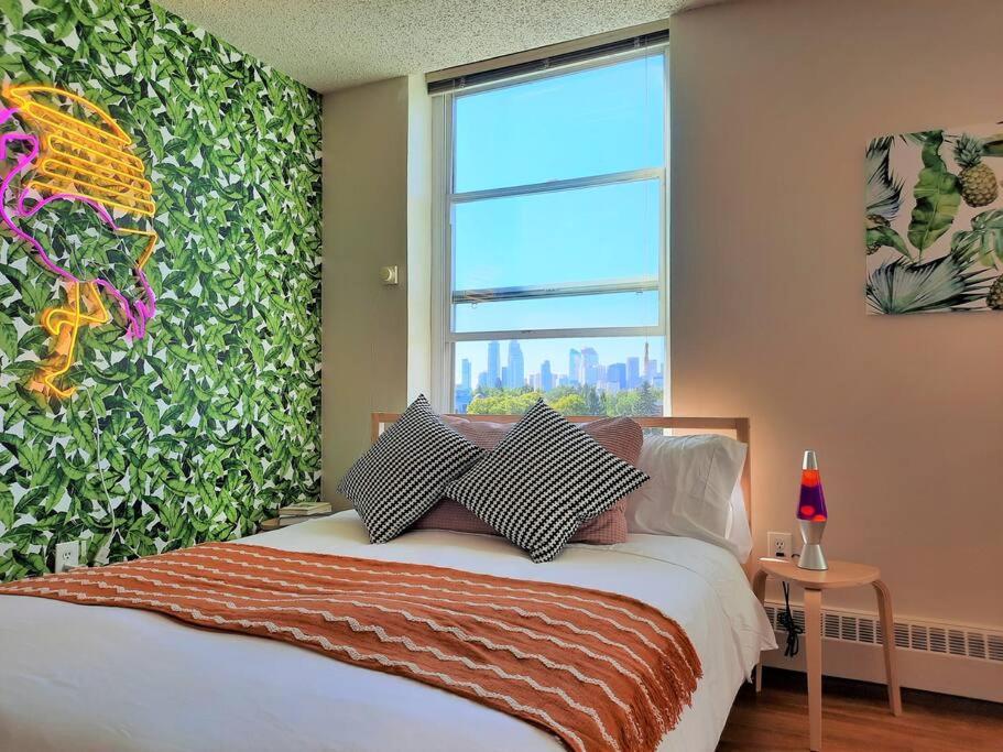 a bedroom with a bed and a large window at Hip Studio w/City Views Minutes to DT in Calgary