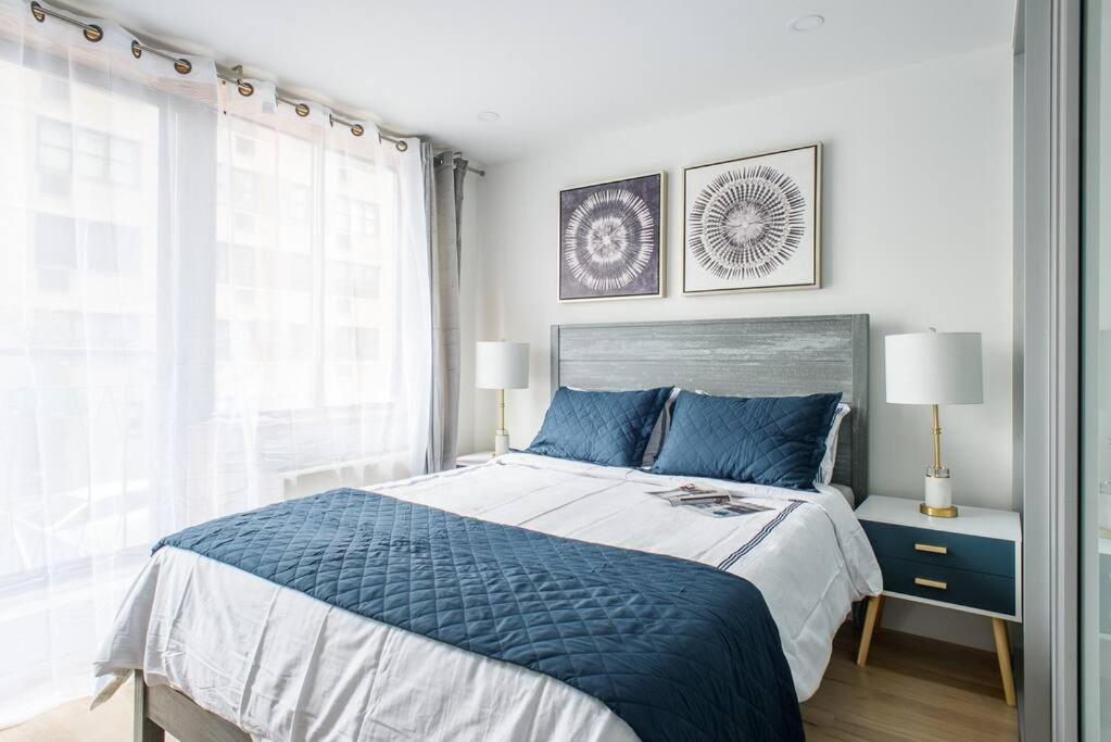 a bedroom with a blue and white bed and a window at 75-1D New 1BR prime UES W D the unit Best Value in New York