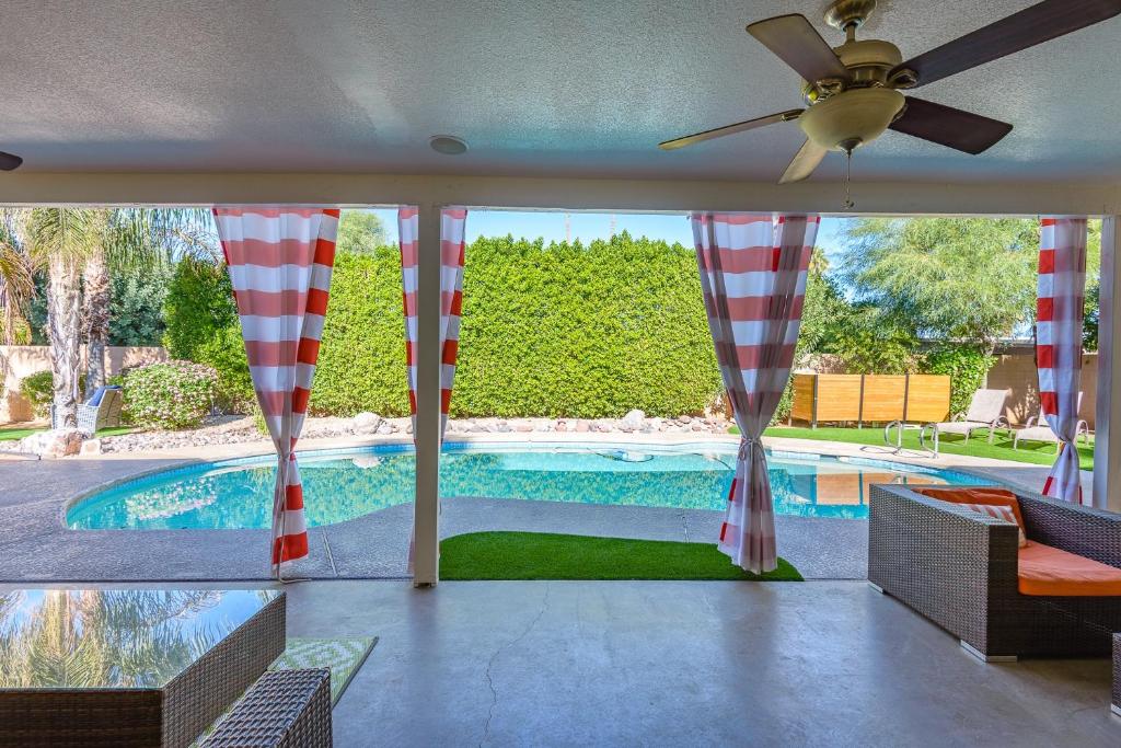 una casa con ventilador de techo y vistas a la piscina. en Casa Del Mar home, en Scottsdale