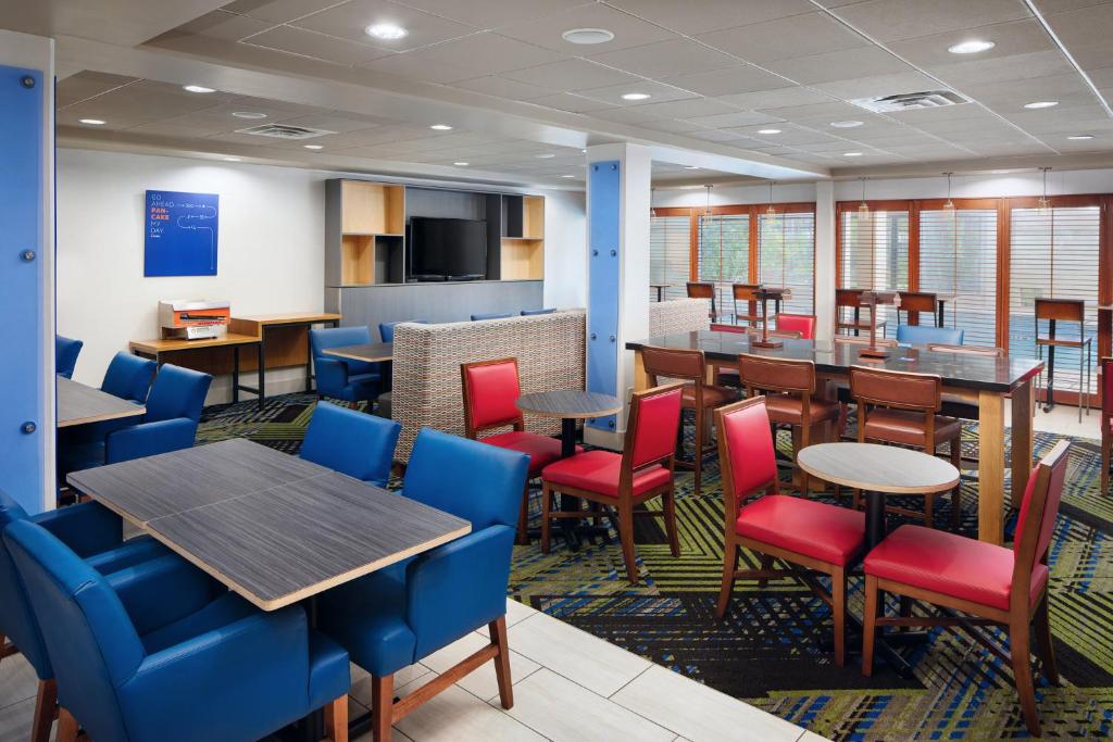 ein Esszimmer mit Tischen und Stühlen in der Unterkunft Holiday Inn Express & Suites Jacksonville South East - Medical Center Area, an IHG Hotel in Jacksonville