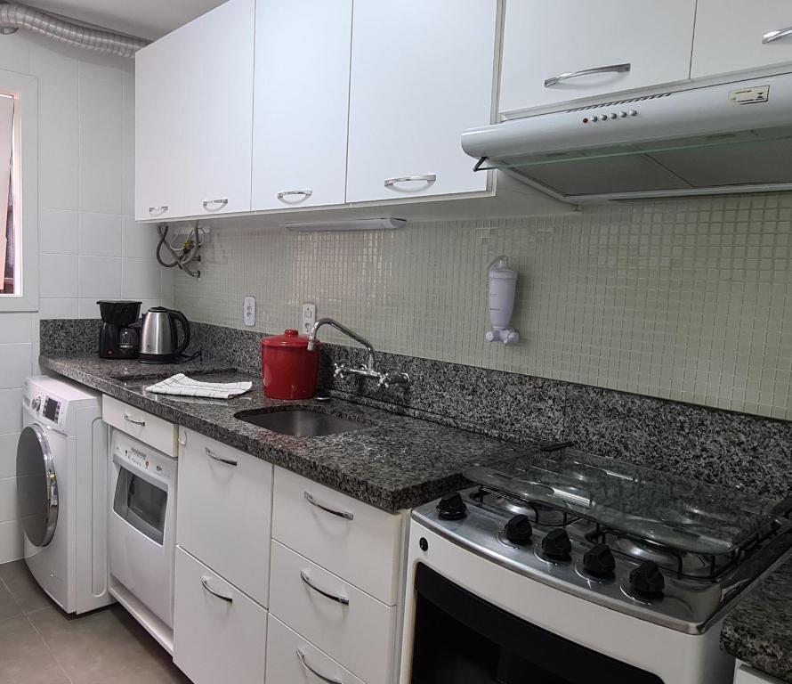 een keuken met een wastafel en een fornuis top oven bij Apartamento no centro de Canela-200 m da Catedral in Canela