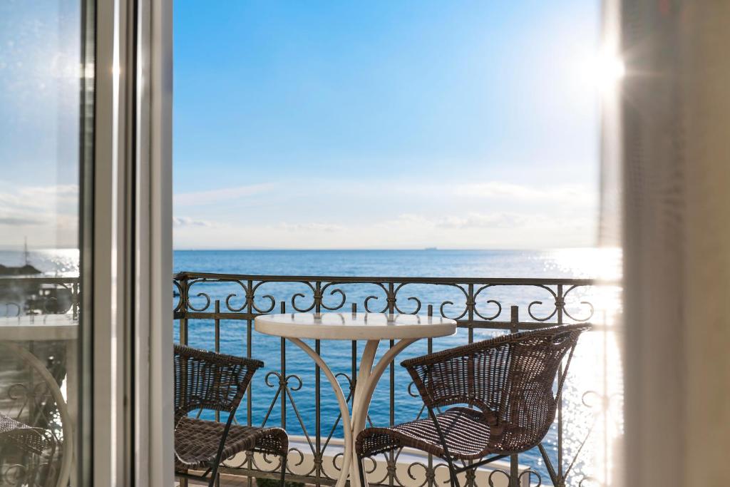 stół i krzesła na balkonie z widokiem na ocean w obiekcie Hotel Villa Schubert w mieście Opatija