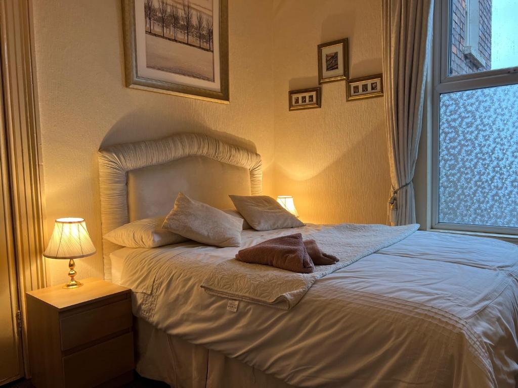 a bedroom with a white bed with a window at Cosy Town House in Belfast
