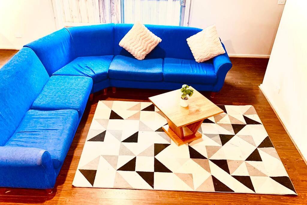 1 sofá azul con mesa de centro en la sala de estar en Charming 4 bedrooms house in Truganina /Williams Landing, en Laverton