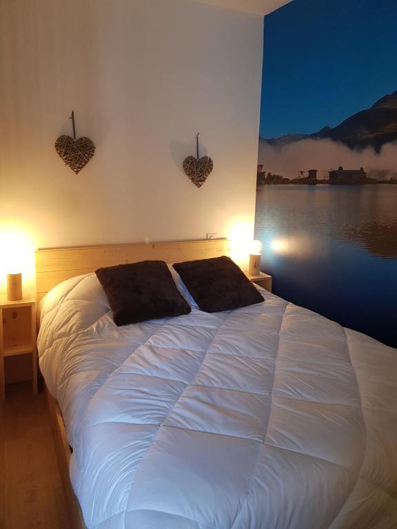 a bedroom with a white bed with two pillows on it at CASTEL ISARD - Le Refuge in Porté-Puymorens