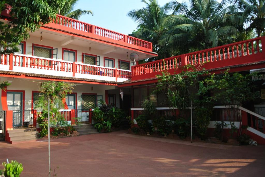 a building with red trim and trees in front of it at Arjun Villa Guest House in Anjuna