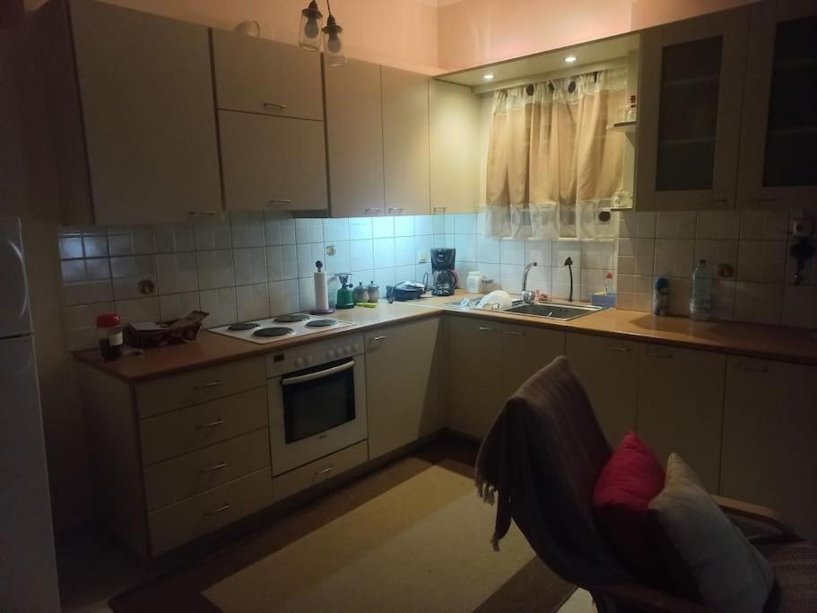 La cuisine est équipée de placards blancs et d'un four avec plaques de cuisson. dans l'établissement Stefkas apartment2, à Patras