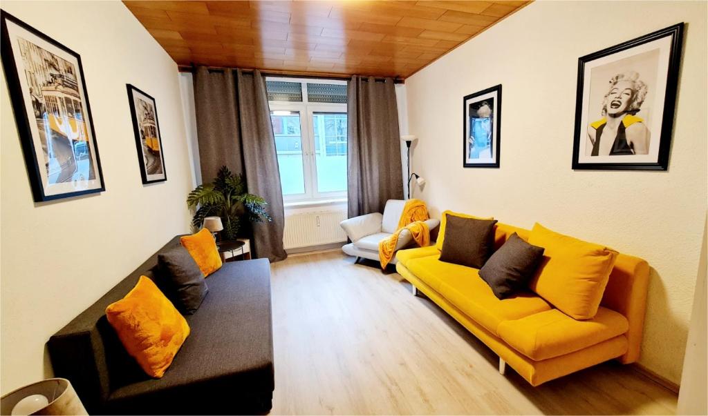 ein Wohnzimmer mit einem gelben Sofa und Stühlen in der Unterkunft ELENA flat Sonnenblumen Duisburg Zentrum in Duisburg