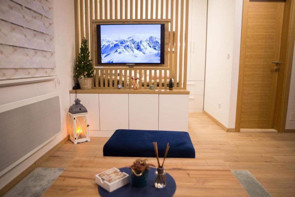 een woonkamer met een televisie aan de muur bij Nomad Jahorina in Jahorina