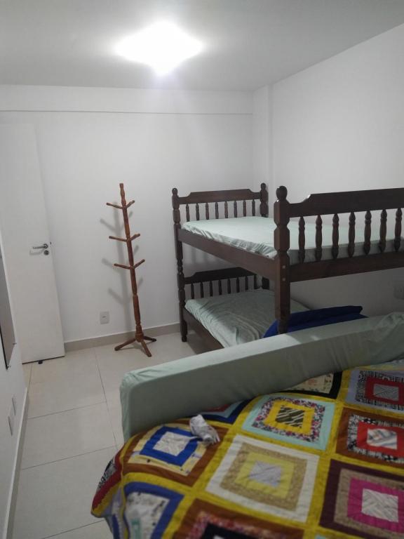 Habitación con 2 literas y alfombra. en Excelente Apartamento em Cabo Frio, en Cabo Frío