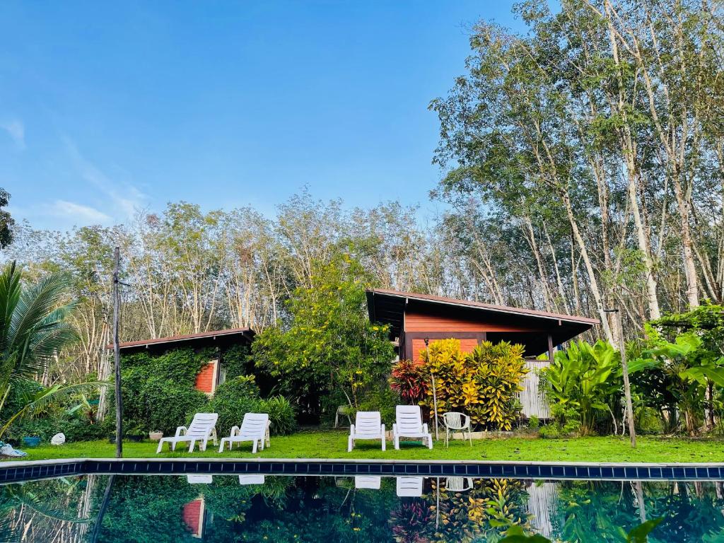 a house with a swimming pool next to a forest at Lok Mun Bungalows in Ko Yao Noi