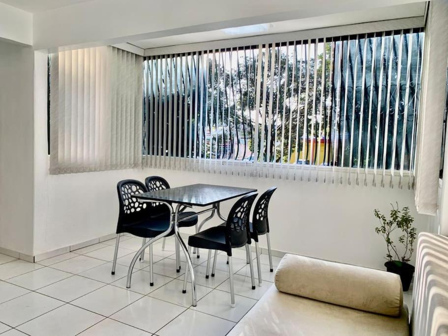 ein Esszimmer mit einem Tisch, Stühlen und einem Fenster in der Unterkunft 3 Quartos Melhor Valor do Df próximo ao Aeroporto e Plano in Brasilia