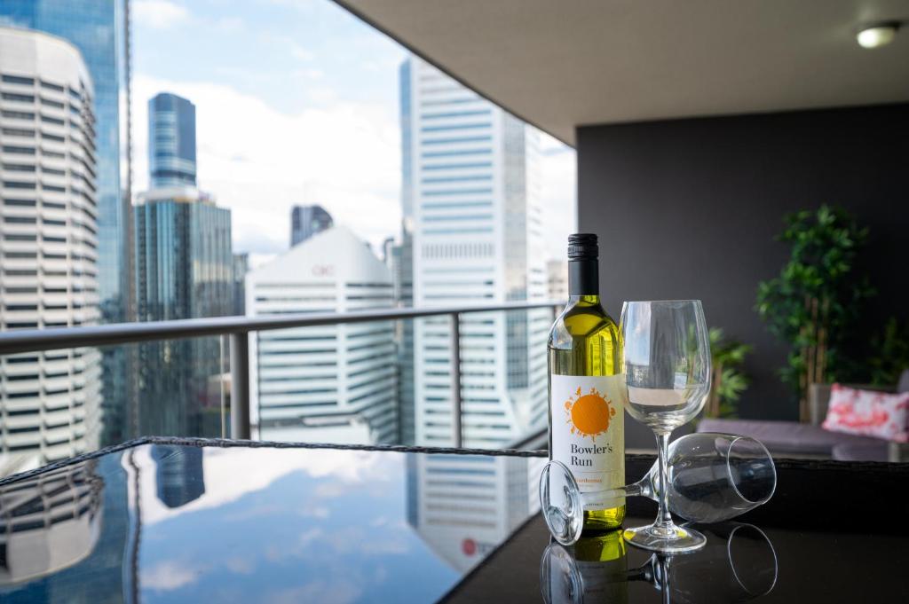a bottle of wine sitting on a table with a glass at Brisbane Break Panoramic River Views Free Parking in Brisbane