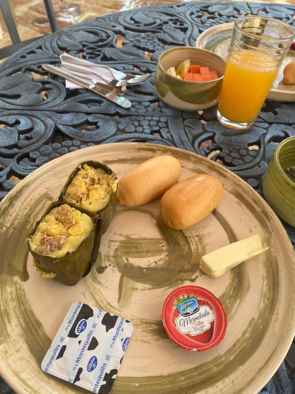 a plate of food on a table with a glass of orange juice at El Principito Hospedaje in Barichara