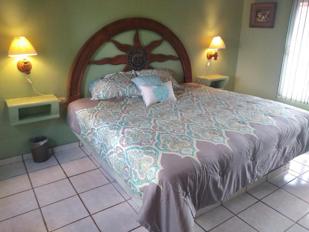 1 dormitorio con 1 cama grande y cabecero de madera en La Casita de la Penita, en Peñita de Jaltemba