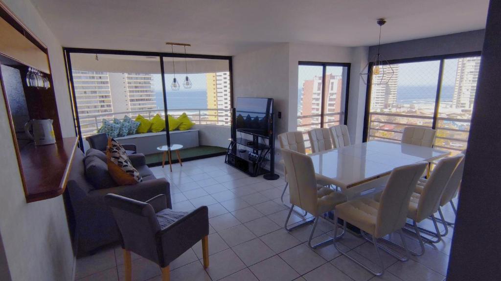 een woonkamer met een eettafel en stoelen bij DEPTO SUITE II in Iquique