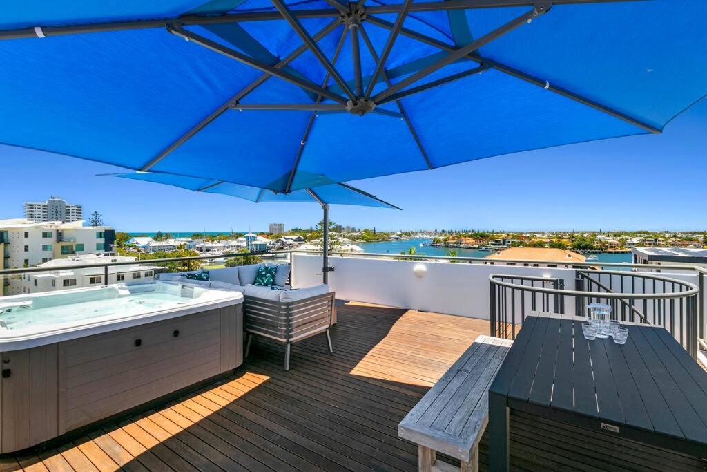 a balcony with a hot tub and an umbrella at Incredible Beachside Penthouse-RIVA11 in Mooloolaba