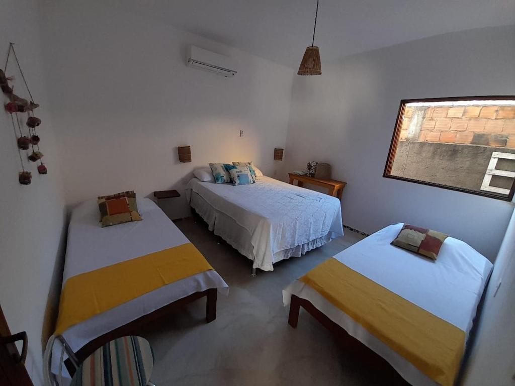 - une chambre avec 2 lits et une fenêtre dans l'établissement Casa Vila Verde, à Porto de Pedras