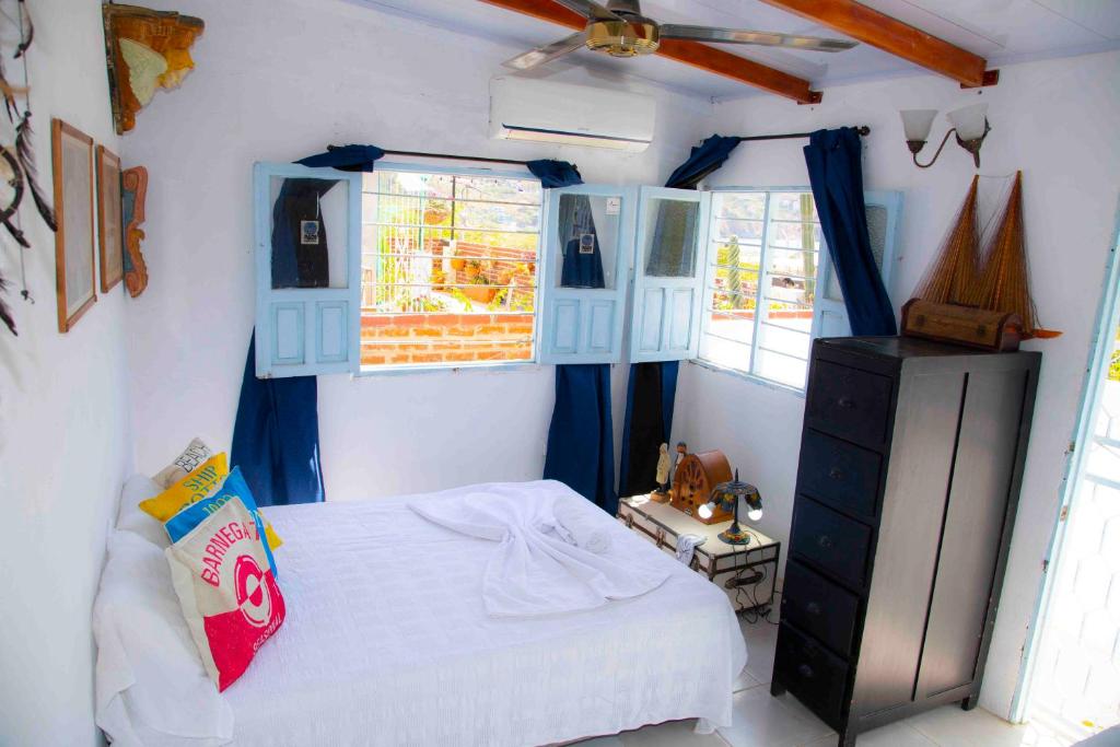 1 dormitorio con 1 cama, vestidor y ventanas en Casa remedios la bella, en Santa Marta
